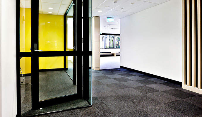 Professional carpet tile cleaning in a modern commercial office hallway and entryway.