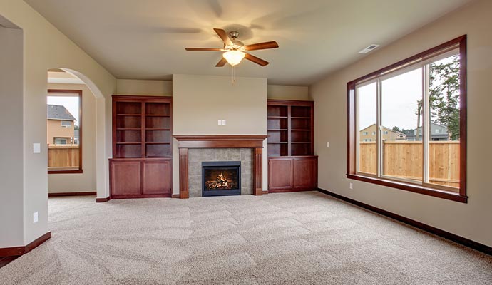 A wide shot of a freshly cleaned and groomed grey carpet in a vacant room