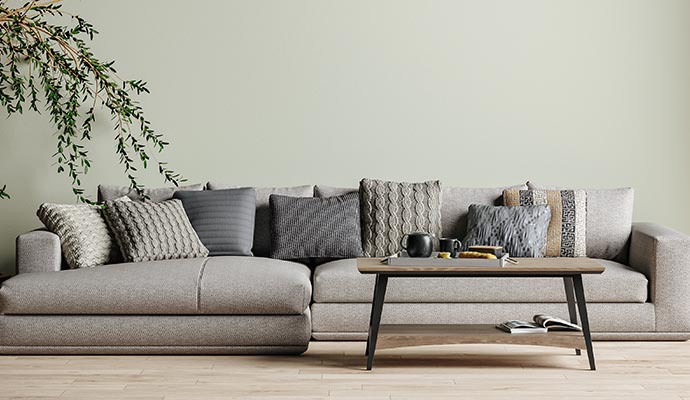 A grey sofa adorned with various textured grey and patterned pillows